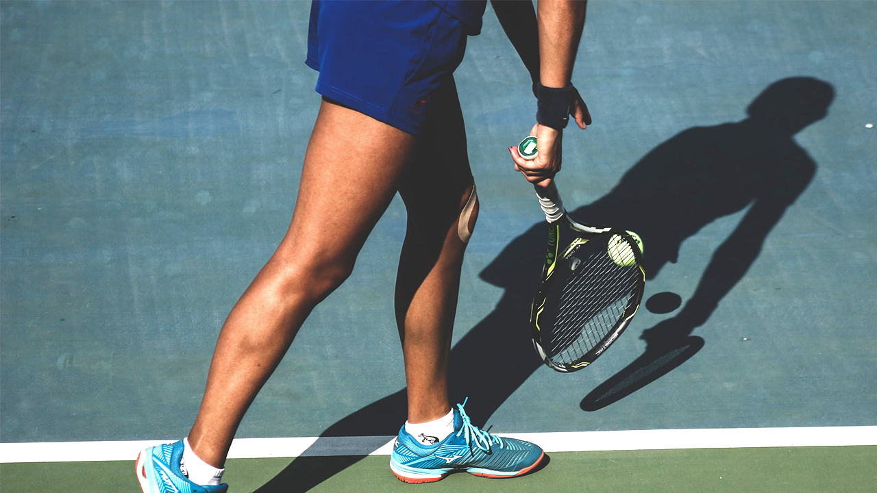 A person playing tennis in a tennis court