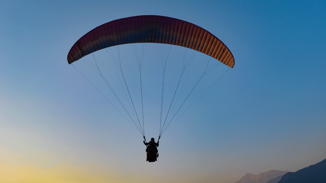 A person paragliding at sunset