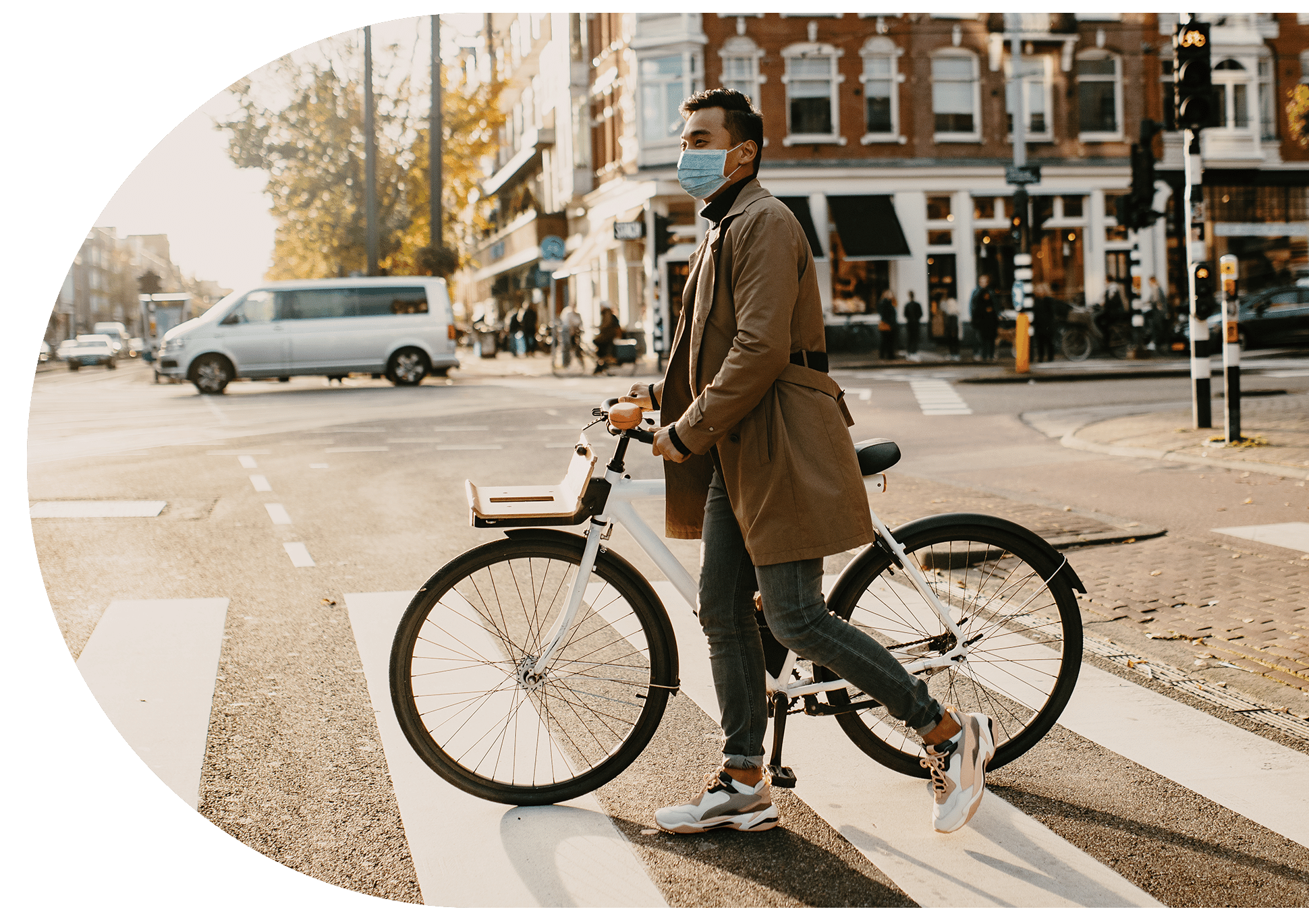 Man walking with a bike across the road