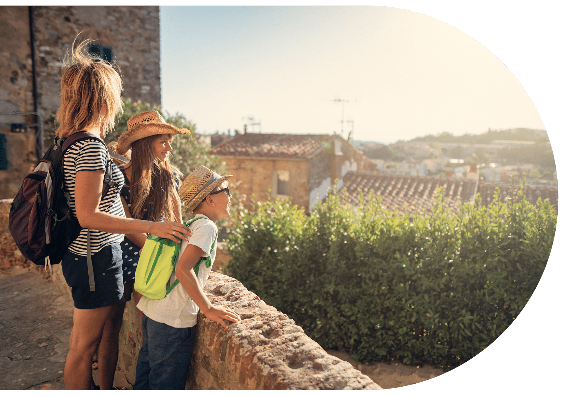 A family looking over a sunny stone balcony