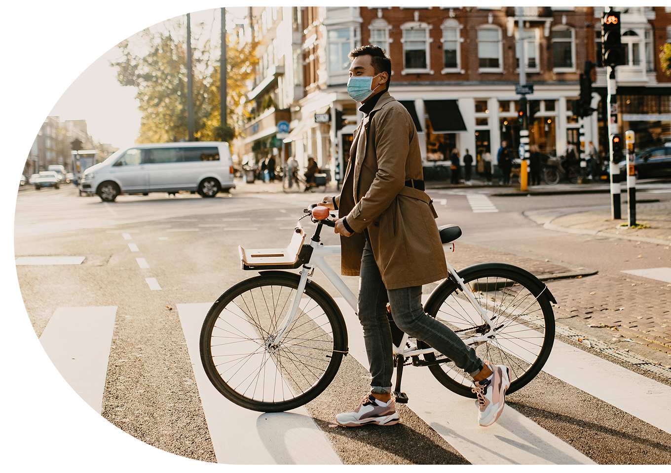 A man walking with a bike across the road