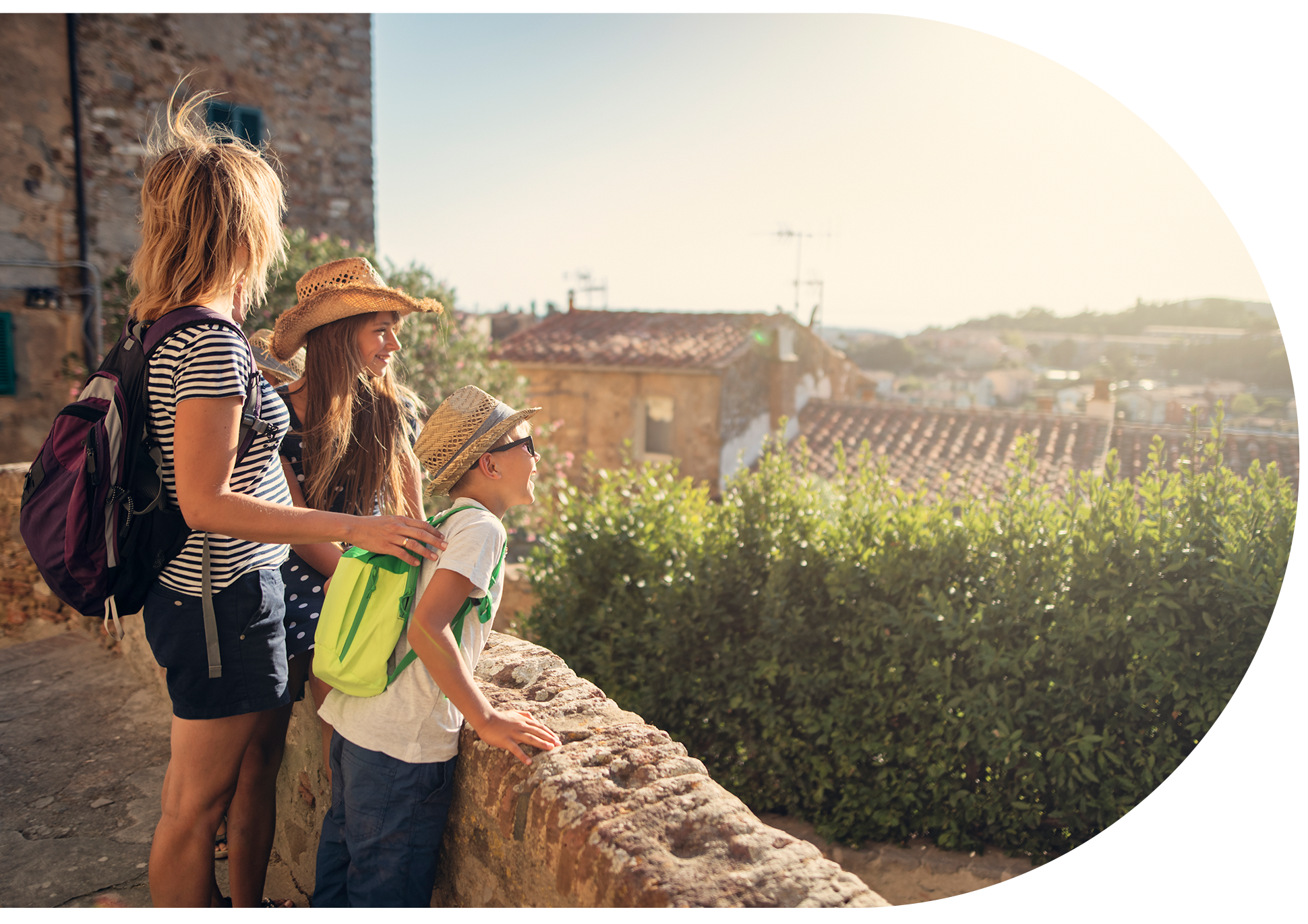 A family looking over a sunny stone balcony