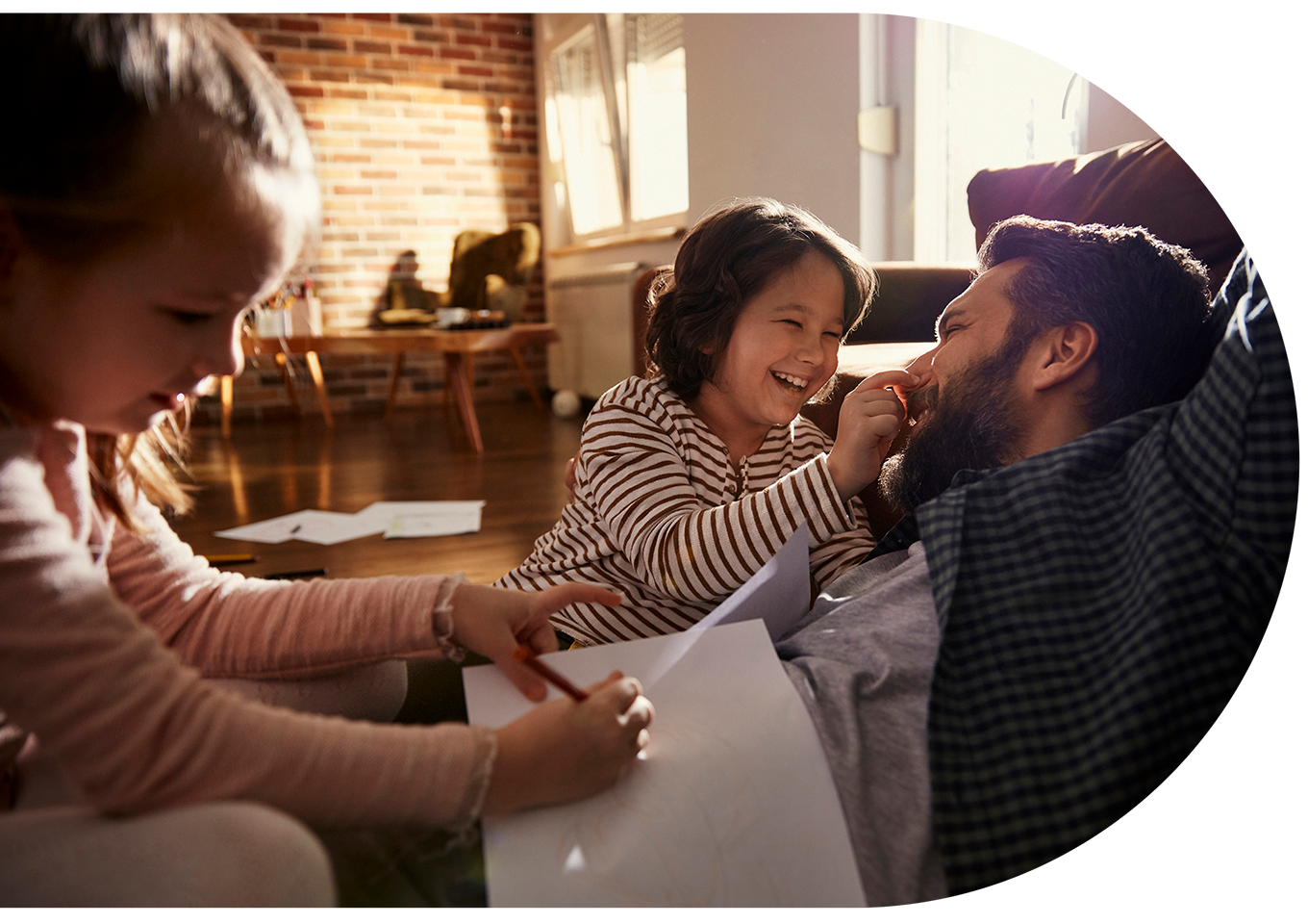 A father and his two children playing and drawing