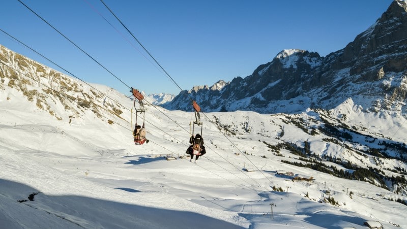 Tourists riding down the First Flyer zipline in Grindelwald, Switzerland