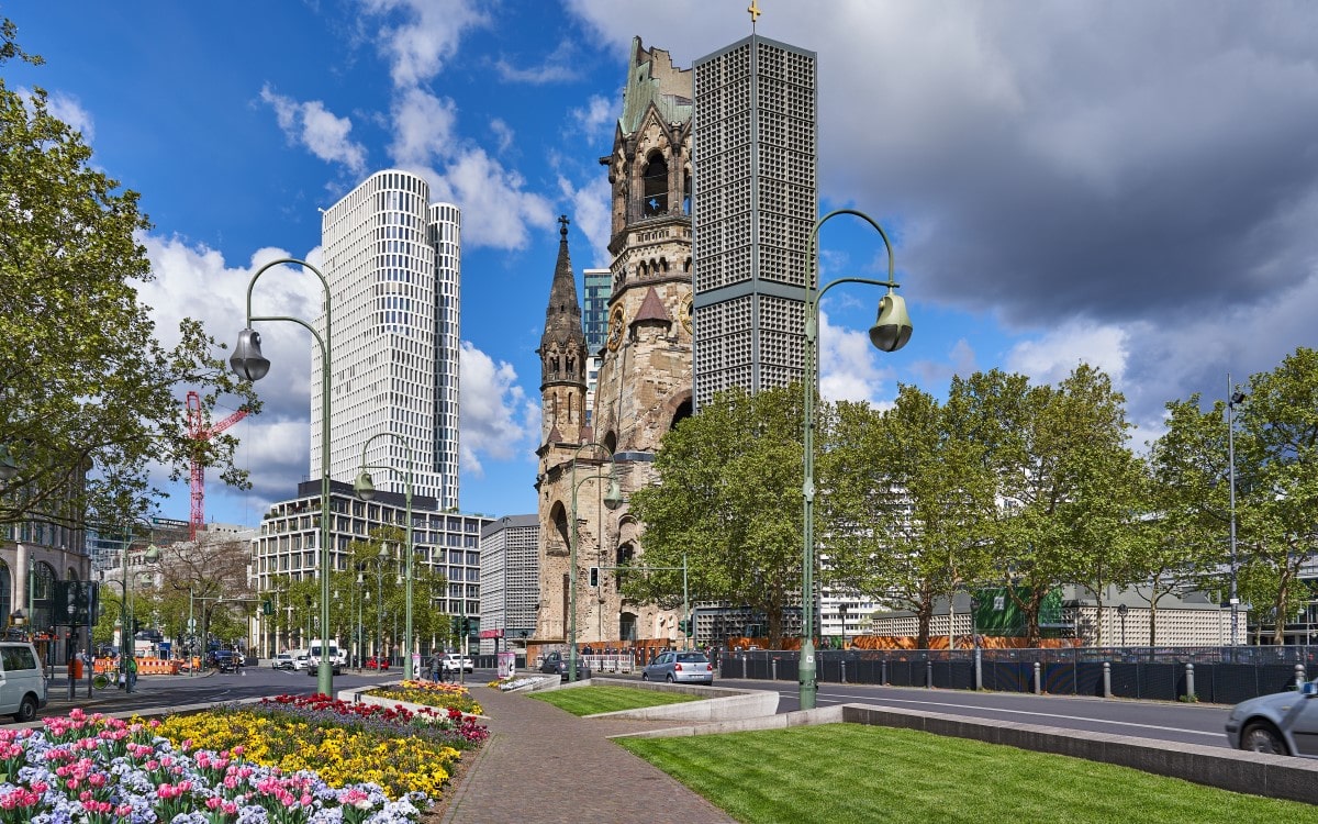 Berlin Memorial Church in spring with colourful tulips in the foreground and a blue sky