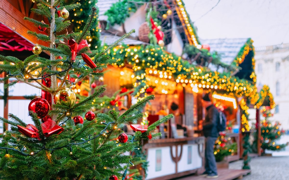 A Christmas decorated pine tree in front of market stalls in Opernpalais, Berlin