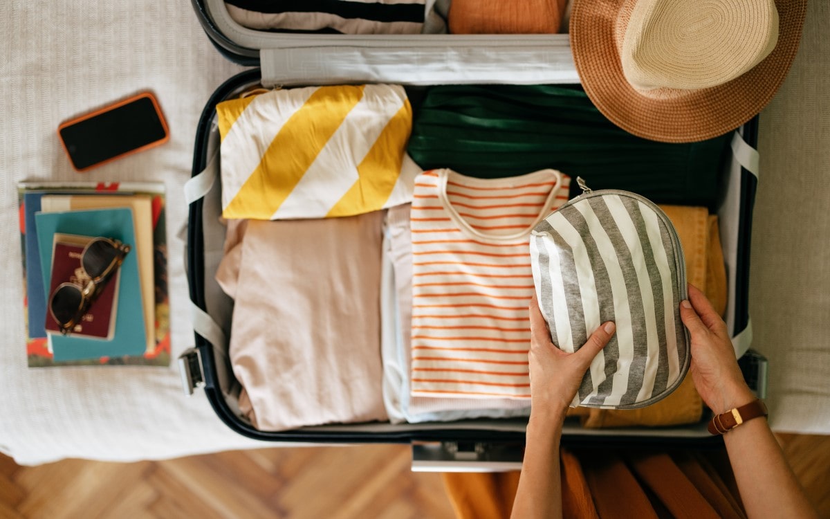 Clothes being packed into a suitcase neatly