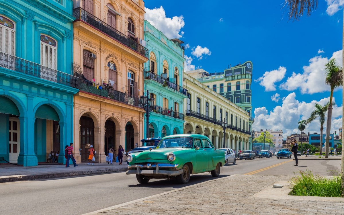 Street view of Havana in Cuba with an old vintage car driving