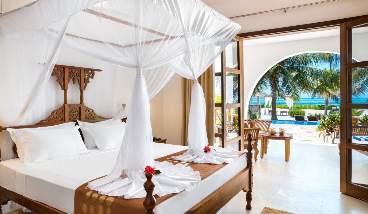 View of a luxury bedroom holiday villa looking out towards the swimming pool and ocean