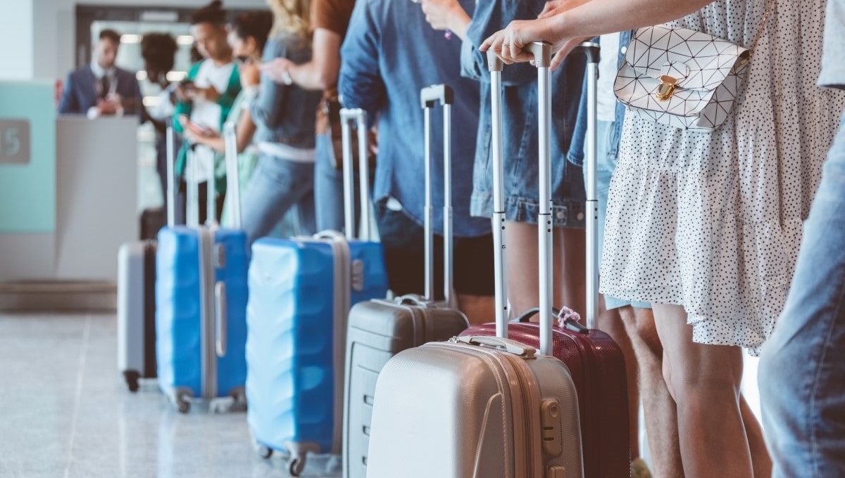 Passengers with luggage while waiting in a line for boarding at an airport